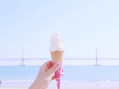 海边手拿东西拍照的图片