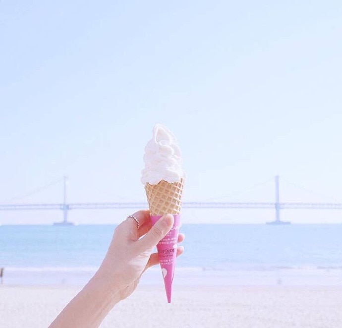 海边手拿东西拍照的图片